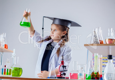 Serious chemist looking at reagent in flask