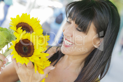 pretty italian woman looking at sunflowers at market