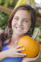 pretty young girl having fun with the pumpkins at market