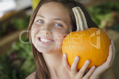 pretty young girl having fun with the pumpkins at market