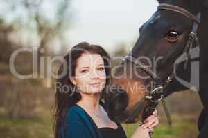 Young woman with a horse on nature