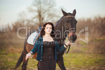 Young woman with a horse on nature