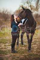 Young woman with a horse on nature
