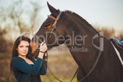 Young woman with a horse on nature