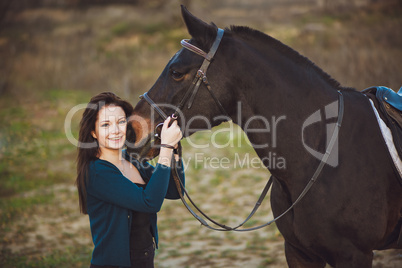 Young woman with a horse on nature