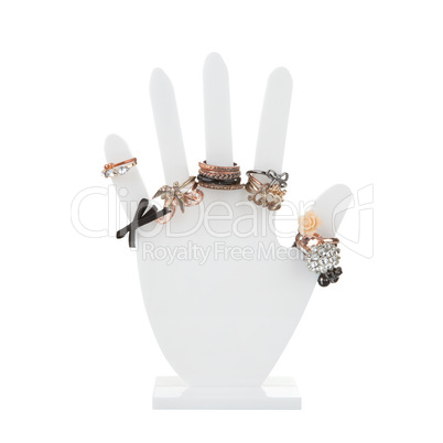 Hand-shaped jewelry holder with variety of rings isolated on whi