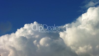 Time lapse clip of white fluffy clouds over blue sky