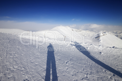shadows of skier and snowboarder on snow