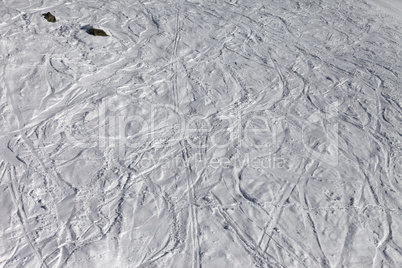 traces of skis and snowboards on off-piste slope