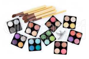 Various eyeshadow palettes, fake eyelashes and cosmetic brushes,