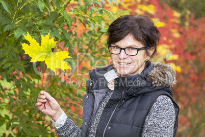 woman in front of autumnal flowering bush
