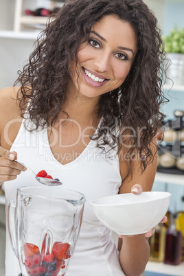 woman making fruit smoothie in kitchen