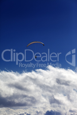 silhouette of paraglider and blue sky with clouds