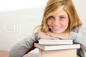 smiling student teenager leaning head on books