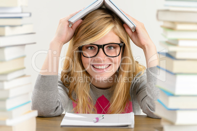 smiling student teenager holding book over head