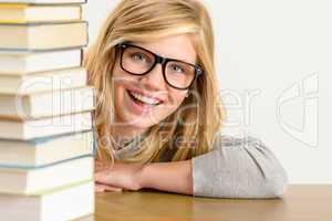 cheerful student teenager look from behind books