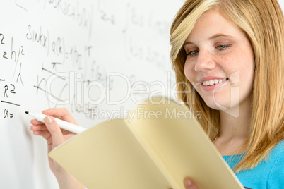 student girl writing maths on white board