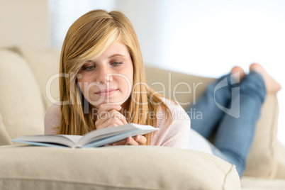 young student girl reading book on sofa