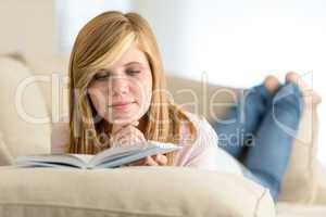 young student girl reading book on sofa