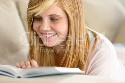 smiling student teenager reading book on sofa