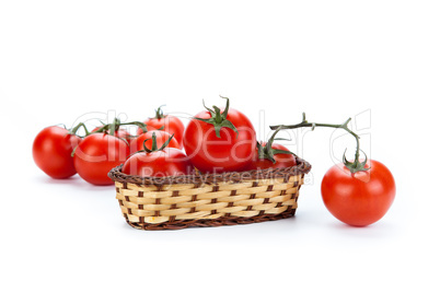 red tomatoes in a small basket on a white background