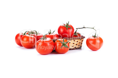 red tomatoes in a small basket on a white background