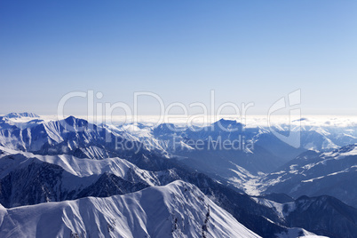 view from off-piste slope on snowy rocks in haze