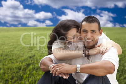 Hispanic Couple Sitting in Grass Field