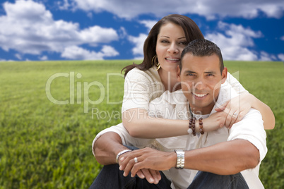 Hispanic Couple Sitting in Grass Field