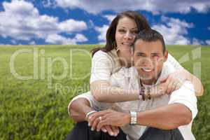 Hispanic Couple Sitting in Grass Field