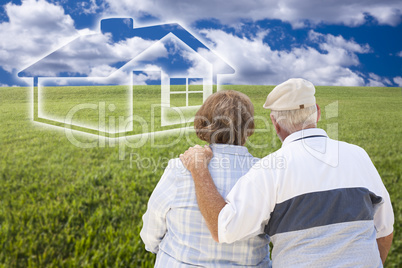 senior couple standing in grass field looking at ghosted house
