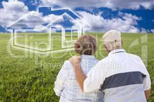 senior couple standing in grass field looking at ghosted house