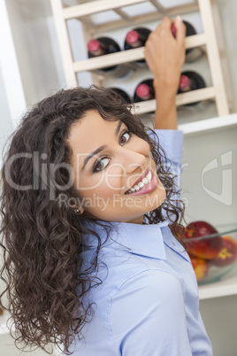 woman choosing bottle of wine in kitchen