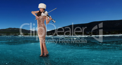 woman playing a violin on a frozen lake