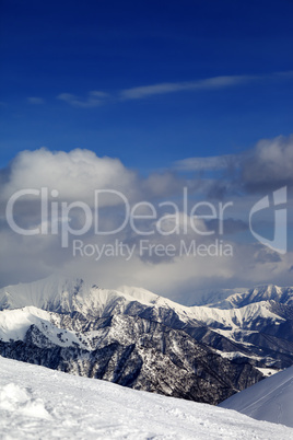 view on cloudy mountains and off-piste slope