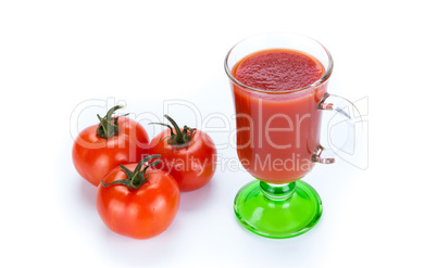 red tomatoes and glass of tomato juice on a white background