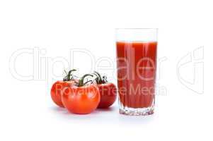 red tomatoes and glass of tomato juice on a white background