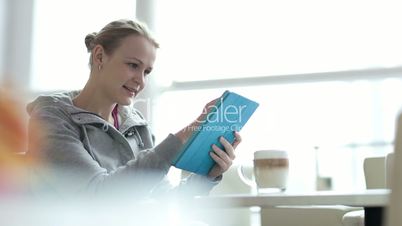 Woman in cafe using her touchpad