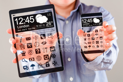 smartphone and tablet with transparent screen in human hands.