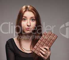portrait of  puzzled young girl with the big chocolate