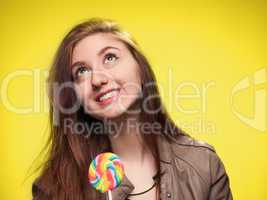 happy young girl with lollipop on a yellow