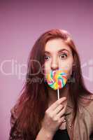 young girl with lollipop on a pink