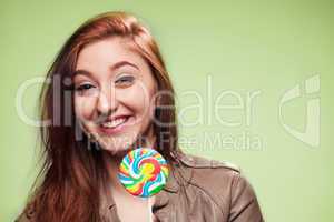 happy young girl with lollipop on a green
