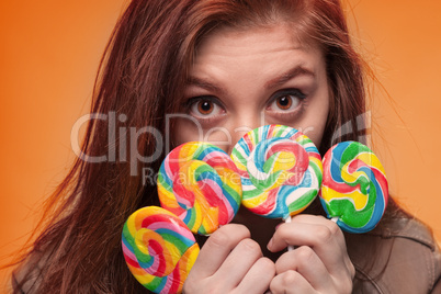 young girl with lollipop on a orange background