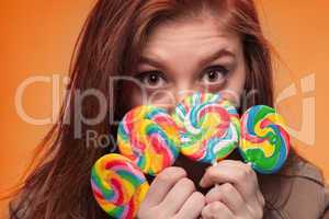 young girl with lollipop on a orange background