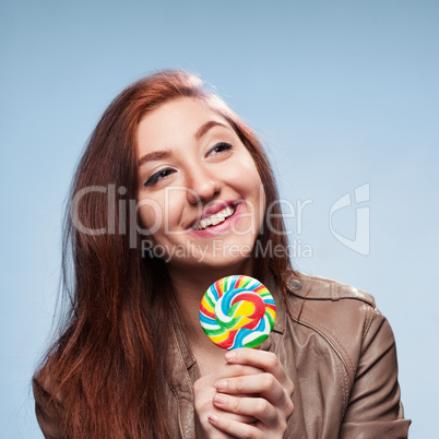 happy young girl with lollipop  on a blue background
