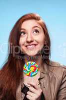 happy young girl with lollipop  on a blue