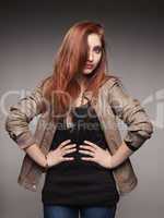 young red-haired girl in a leather jacket represents model