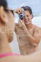 couple at beach taking photographs