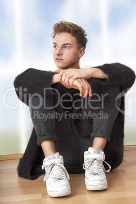 casual dressed man sitting on the floor